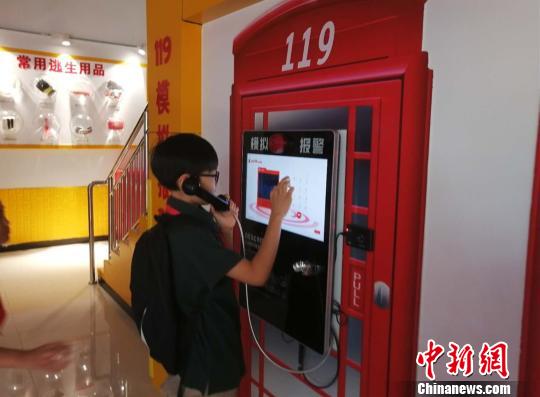 圖為一名小學生模擬撥打119火警電話 劉鵬 攝